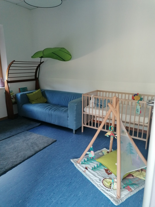 Rest corner with a sofa and a baby crib