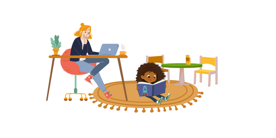 Woman sitting at a table with a laptop and child sitting on the floor reading a book on a round rug in a room with chairs and a small table