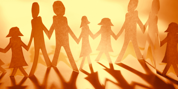Stilisierte Papierfiguren einer Familie, die sich an den Händen halten