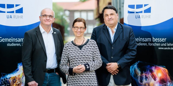 Drei Menschen stehen nebeneinander und schauen lächelnd in die Kamera. Prof. Dr. Links steht Manfred Bayer, Rektor der TU Dortmund. In der Mitte steht Prof. Dr. Barbara Albert, Rektorin der Universität Duisburg-Essen. Rechts steht Prof. Dr. Martin Paul, Rektor der Ruhr-Universität Bochum.