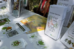 Information booth table outdoors with flyers and stickers about family service.
