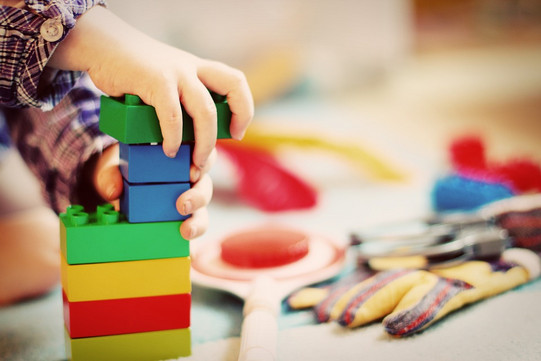 close-up of a child's hand holding colorful building bricks