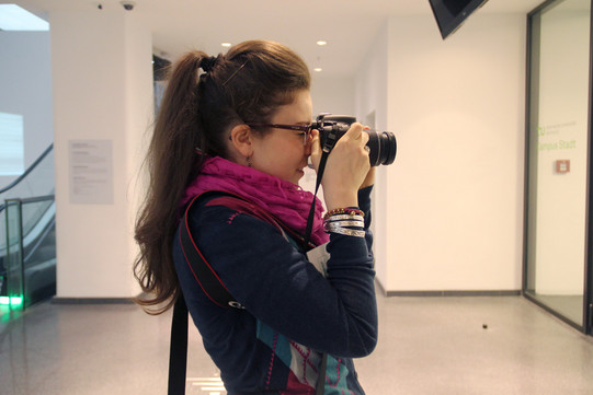 A woman looks through a camera