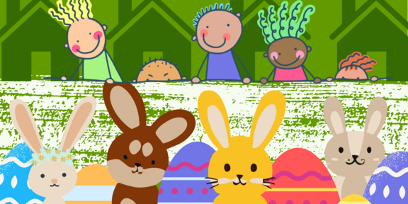  A collection of Easter bunnies sits on a meadow. A row of houses can be seen behind them. In front of this row of houses, children are looking over the wall at the Easter bunnies. 