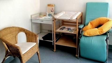 Baby changing and breastfeeding room In one corner there is a changing table and also a nursing chair