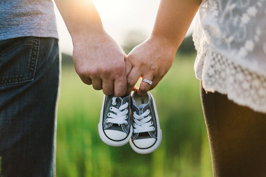 close-up of a couple holding baby shoes