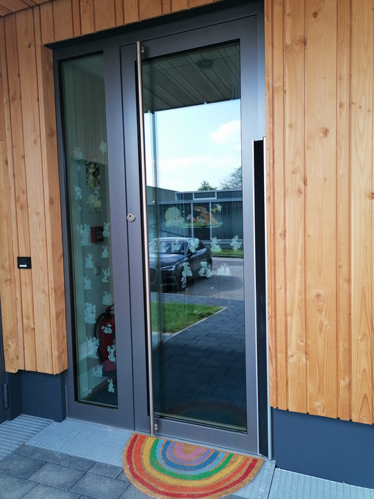 Gray glass entrance door to the facility Schlauschlümpfe