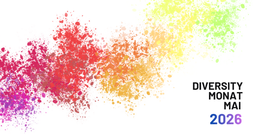 Bunte Farbspritzer in Regenbogenfarben mit dem Text 'DIVERSITY MONAT MAI 2026' rechts daneben