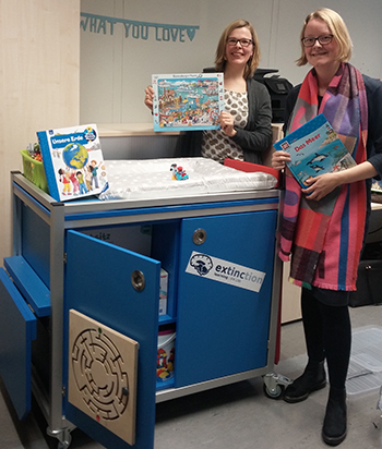 Eine blaue KidsBox dabei stehen Prof. Dr. Sarah Weigelt und Frau Dr. Regina Moritz 