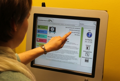 someone operates a touchscreen monitor