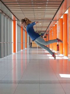 Woman floats through the air in a corridor