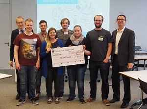 Winning team thyssenkrupp ManagerCup with 8 people of different genders, two women holding a check 