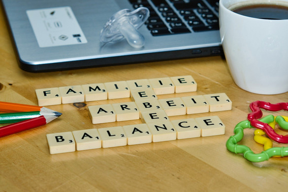 Laptop, Kaffeetasse, Stift, Schnuller, Beißring und Slogan "Familie, Leben, Arbeit, Balance"