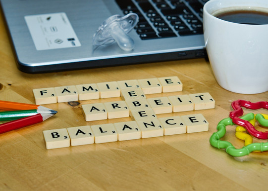 Laptop, Kaffeetasse, Stift, Schnuller, Beißring und Slogan "Familie, Leben, Arbeit, Balance"