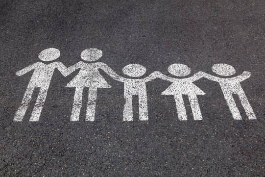 Eine weiße Kreidezeichnung von einer Familie auf dem Boden.